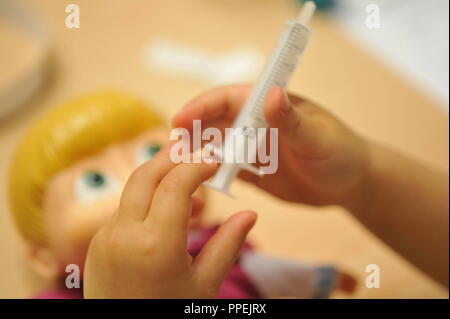 Spritze, Spielzeug für Kinder, aus der Tüte ist ein Arzt mit Spritze, Spielzeug für Kinder, aus der Tüte ist ein Arzt mit