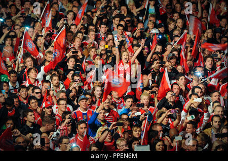 Fans des FC Bayern München feiern auf dem Marienplatz in München vor dem Rathaus, wo das Team des Deutschen Fußball-Datensatz Meister auf dem Balkon wird im Anschluss an den Empfang durch den Bürgermeister Dieter Reiter angezeigt. Stockfoto