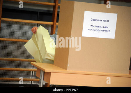 Geheim ist das Zeichen Wahlzettel der Wahlkabine einzeln eingeben "in einer Wahlkabine im Wahllokal an der Grundschule in der Plinganserstrasse in Sendling. Stockfoto