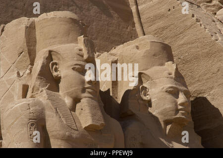 Ägyptische Kunst Großen Tempel von Ramses II. Zwei kolossale Statuen, die den Pharao Ramses II (1290-1224 v. Chr.) Mit dem nemes Kopf sitzt und durch die doppelte Krone überragt. 19. Dynastie. Neuen Reich. Abu Simbel. Ägypten. Stockfoto