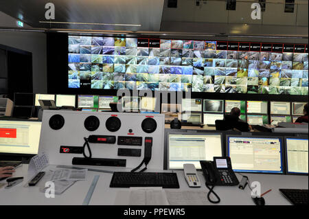 Ein Mitarbeiter in der neuen Traffic Control Center in den Technischen Betrieb Zentrum von baureferat in der Schragenhoferstrasse in Moosach. In dem dunklen Raum zwei Verkehr Betreiber von der Abteilung für öffentliche Ordnung zusammen mit zwei Polizisten und drei Mitarbeiter der Abteilung für öffentlichen Bau vor einem riesigen Monitor Wall sitzen und überwachen den gesamten Verkehr in München und zu steuern. Stockfoto