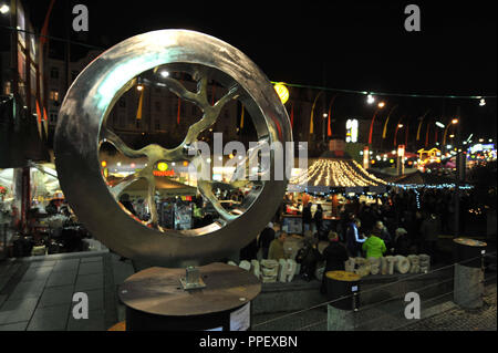 Die Schwabinger Weihnachtsmarkt an der Münchner Freiheit. Im Vordergrund die Skulpturen Forum. Stockfoto