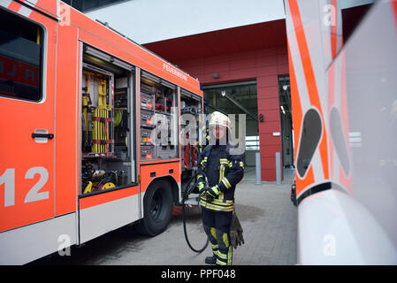 Porträt eines Feuerwehrmann am Einsatzfahrzeug in der Feuerwache Stockfoto
