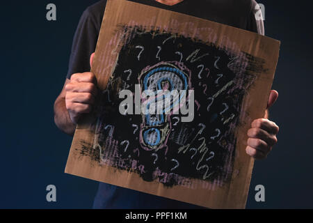 Mann fragen, männliche Person, die Pappe Papier mit Fragezeichen Stockfoto