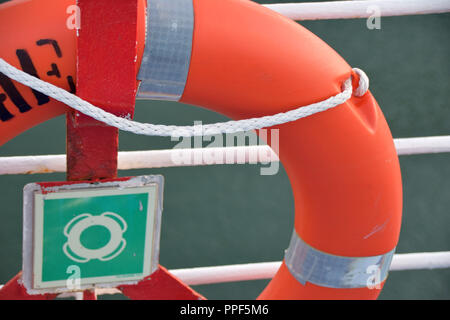 Nahaufnahme eines Rettungsring auf das Geländer eines Schiffes, ein Teil von einem Rettungsring mit dem Symbol in der Mitte Stockfoto