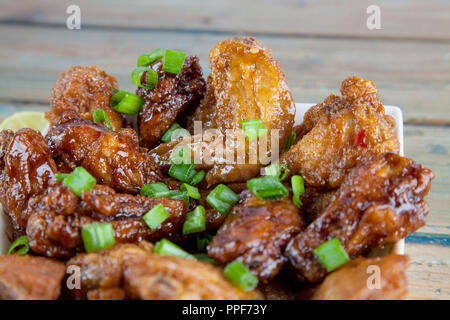 Zitrone tantalizing Chicken Wings in eckigen Schale Nahaufnahme Stockfoto