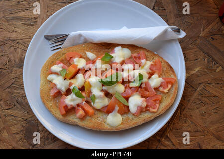 Bruschetta auf weißer Teller mit Besteck und Serviette, in eine italienische Vorspeise Bruschetta mit Tomaten und Mozzarella und Basilikum auf geröstetem Brot Stockfoto