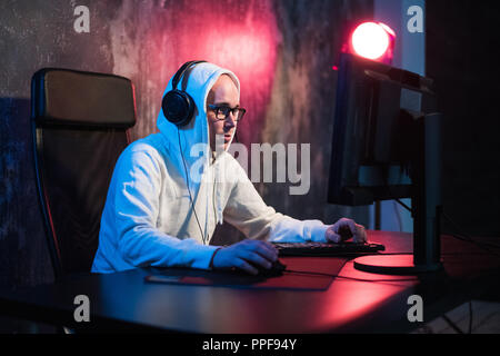 Männliche hooded Gamer spielen online Spiel auf pc Stockfoto