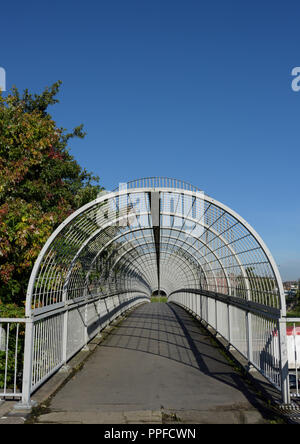 Geschlossene Fußgängerbrücke mit Stahlkäfig, über M60 Autobahn an der Ausfahrt 17, kreuzung whitefield im Großraum manchester, großbritannien Stockfoto