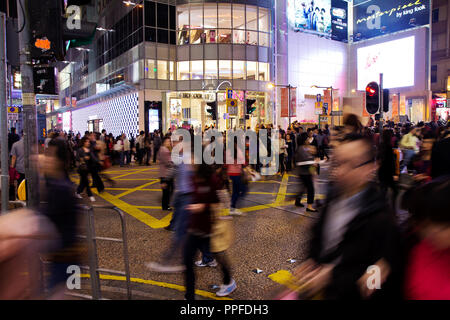 Einkaufsstraße in Hong Kong, Kreuzung bei Nacht mit Fußgängern in Hongkong, China am 20. April 2011 voll Stockfoto