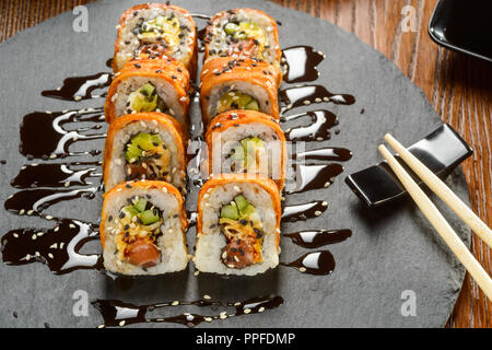 Sushi Rollen bestreut mit Sauce Stockfoto