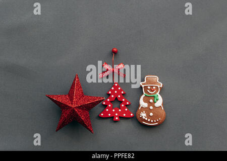 Weihnachten Spielzeug und Lebkuchen in der Form eines Schneemann auf einem grauen Hintergrund. Weihnachten oder Neujahr Konzept. Stockfoto