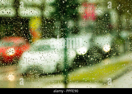 Regnerischen Tag auf der Straße durch das Auto Glas mit Regentropfen Stockfoto