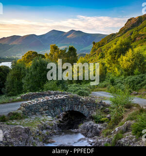 Ashness Brücke und die letzten Sonnenstrahlen auf den Bergen oberhalb von Derwentwater, Lake District, Cumbria, England Stockfoto