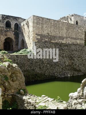 Syrien. Talkalakh Bezirk, Krak des Chevaliers. Crusader Castle, unter der Kontrolle der Ritter Johanniter (1142-1271) während der Kreuzzüge in das Heilige Land, fiel in die Arabischen Steuerung im 13. Jahrhundert. Blick auf den Burggraben. Foto vor dem syrischen Bürgerkrieg. Stockfoto