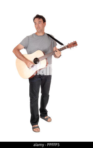 Ein junger stattlicher Mann mit seiner Gitarre und Wiedergabe eines Songs in Jeans und T-Shirt, auf weißem Hintergrund Stockfoto
