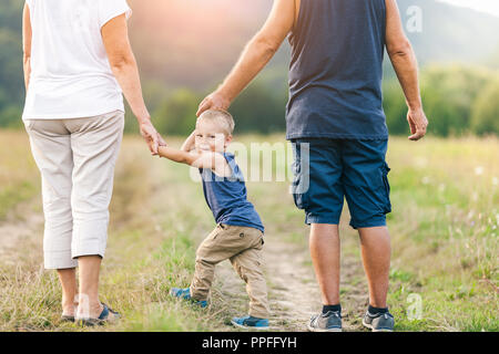 Glückliche Großeltern auf einem Spaziergang ausserhalb mit ihren Enkel Stockfoto