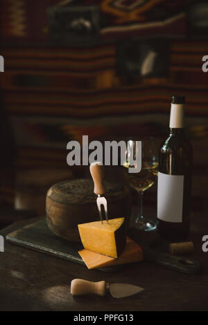 Schnittkäse mit Weißwein auf rustikalen Holztisch Stockfoto