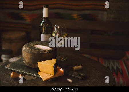 Käse mit Weißwein auf rustikalen Holztisch Stockfoto