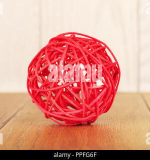 Red rattan Ball liegen auf Holz- Hintergrund Stockfoto