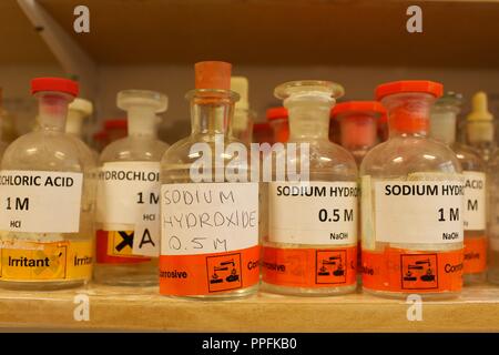 Verschiedene Flaschen mit Chemikalien einschließlich Natriumhydroxid in einer Schule Chemie Labor Stockfoto