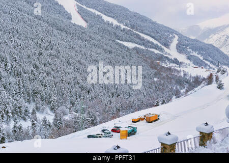 Blick auf die Skipisten und das Parken der Autos an einem Hang. Skipisten zwischen Tannen, es gibt eine Menge Schnee, Bäume im Schnee Stockfoto