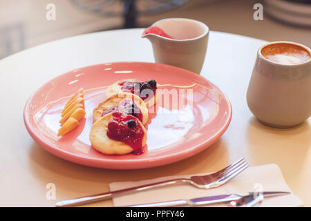 Frühstück im Cafe Käsekuchen mit Früchten und Kaffee Stockfoto