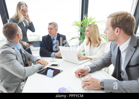 Gruppe von Geschäftsleuten über eine finanzielle Dokumente in der Sitzung Stockfoto