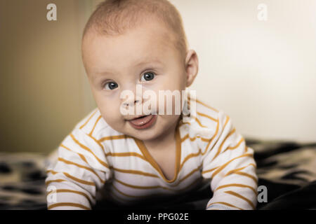 Porträt einer expressiven Happy Baby, hält Kopf an. baby Entwicklung Konzept Foto, Lifestyle. Stockfoto