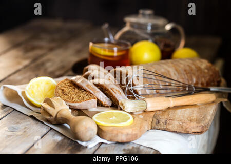 Earl Grey Tee mit hausgemachten Kuchen mit Zitrone Puderzucker und Tee. Copyspace Hintergrund. Stockfoto