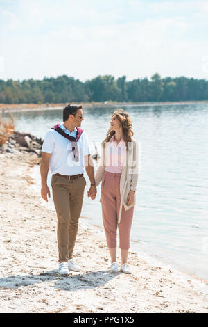 Romantisches Paar Hände halten beim Gehen auf sandigen Riverside Stockfoto