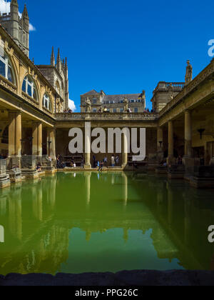 Historische große Badewanne der römischen Bäder in Bath Abbey im Hintergrund (links), Badewanne, Somerset, England, UK. Stockfoto
