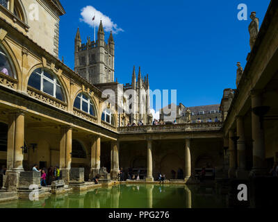 Besucher die Erkundung der historischen römischen Bädern mit Badewanne Abtei überragt, Badewanne, Somerset, England, UK. Stockfoto