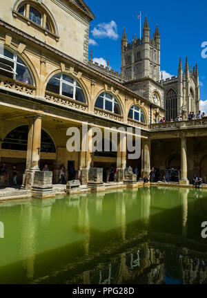 Besucher die Erkundung der historischen römischen Bädern mit Badewanne Abtei überragt, Badewanne, Somerset, England, UK. Stockfoto