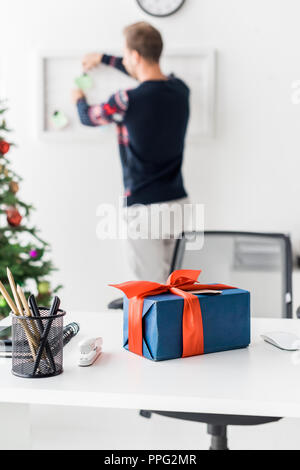 Weihnachten Geschenk Box auf dem Tisch und Unternehmer arbeiten an Hintergrund Stockfoto