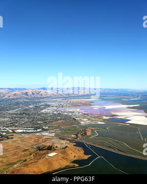 San Francisco Bay Area: Luftaufnahme von Feuchtgebieten Sümpfe in der South Bay, mit den bunten Salz Teiche in der Ferne. Stockfoto