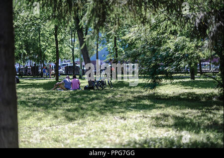 Ruhe im Park auf dem Gras. Paar ruht, sitzen auf der Wiese, mit Fahrrädern Stockfoto