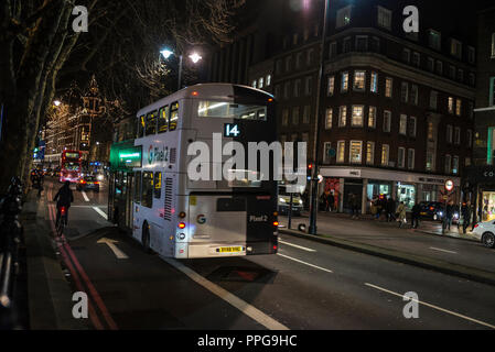 London, Großbritannien - 3. Januar 2018: Bus mit Google Werbung zirkulierenden Nachts mit Menschen um in London, England, Vereinigtes Königreich Stockfoto