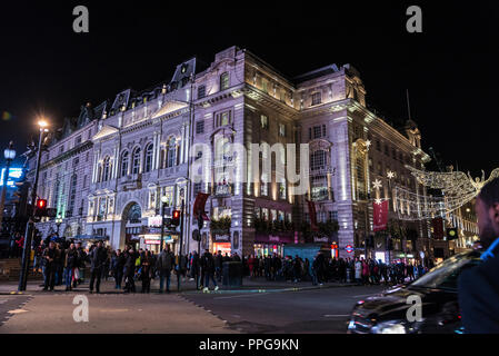 London, Großbritannien - 3. Januar 2018: Piccadilly Circus mit dem Kriterium Theater im Hintergrund bei Nacht mit Weihnachten Dekoration und Menschen Stockfoto