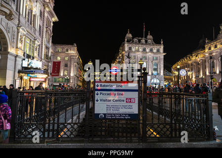 London, Großbritannien - 3. Januar 2018: Eingang der U-Bahnstation der Piccadilly Circus bei Nacht mit Weihnachten Dekoration und Menschen aroun Stockfoto