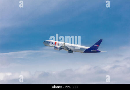 FedEx Frachtmaschine in Anchorage Alaska in einem blauen Himmel mit weißen Wolken Stockfoto