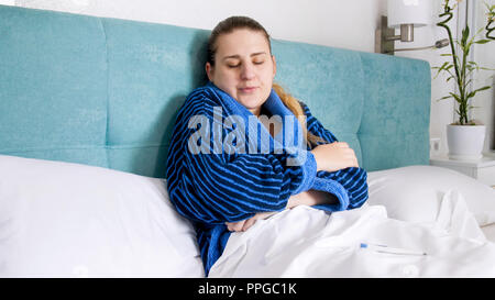 Portrait von Müde traurige Frau im Bademantel im Bett zu Hause. Stockfoto