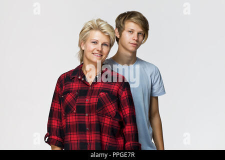 Glücklich und lächelnd Mutter und Sohn. Liebevolle Familie Portrait vor weißem Hintergrund Stockfoto