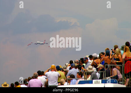 Virgin Atlantic Boeing 747 Jumbo Jet Flugzeug fliegt in Formation mit der RAF, Royal Air Force Red Arrows zeigen Mannschaftsjets mit nachfolgender Rauchentwicklung. Airshow. Fluggesellschaft Stockfoto