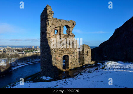 Ruinen von St Anthony's Kapelle im Schnee, mit St Margaret's Loch im Hintergrund, Holyrood Park, Edinburgh, Schottland Stockfoto