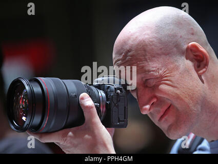 26. September 2018, Nordrhein-Westfalen, Köln: Ein Messebesucher testet eine spiegellosen Digitalkamera (Canon EOS R). Fotografie Photokina, der größten Messe der Welt, wird in Köln stattfinden, bis 29. September 2018. Foto: Oliver Berg/dpa Stockfoto