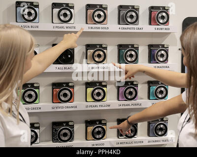 26. September 2018, Nordrhein-Westfalen, Köln: Hostessen zeigen auf die sofortige Kamera Fujifilm Instax Square SQ6. Fotografie Photokina, der größten Messe der Welt, wird in Köln stattfinden, bis 29. September 2018. Foto: Oliver Berg/dpa Stockfoto