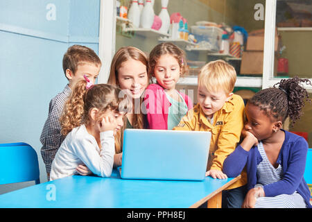 Lehrer und Gruppe von Kindern zusammen Lernen am Laptop Computer in der Grundschule Stockfoto