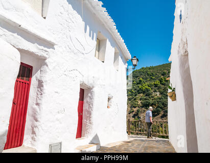 Ältere Mann, der Panama Hut neben weißen Häuser bewundern Bergblick in alten maurischen Dorf Salares, Axarquia, Andalusien, Spanien Stockfoto