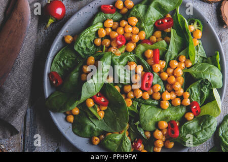 Kichererbsen und Gemüse Salat mit Spinat Blätter, gesund Hausgemachte veganes Essen, Diät. weiße Bohnen in Tomatensoße Stockfoto